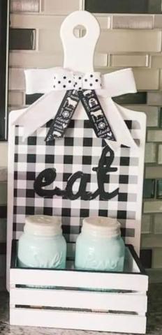 Kitchen Caddie looks like a cutting board with a handle with a tray holding two jars